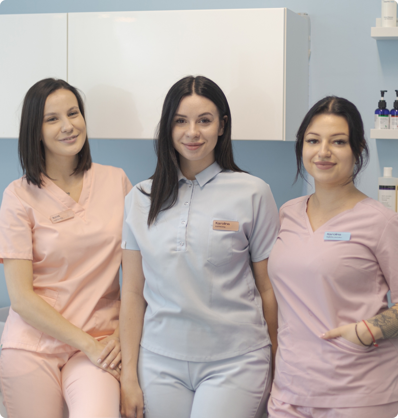 Zespół Gabinet Dziewczyny - trzy specjalistki w pastelowych uniformach, pozujące w studio na białym tle, promieniujące profesjonalizmem i serdecznością.